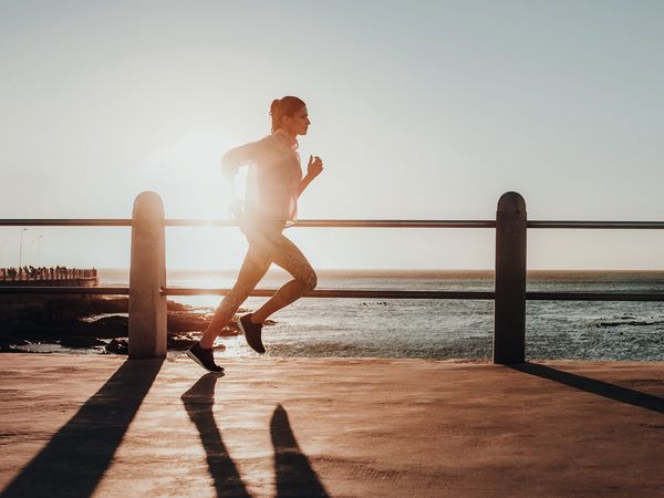 Eine Frau läuft im Sonnenuntergang, um keine Rückenschmerzen zu haben.