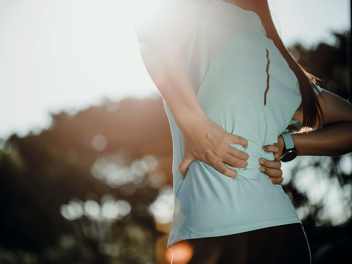 Eine Frau hält sich den Rücken.