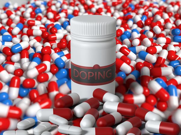 Eine Pillendose mit der Aufschrift „Doping“ und zahlreichen Tabletten davor