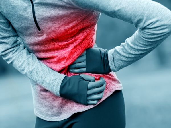 Eine Frau hat Seitenstechen beim Laufen