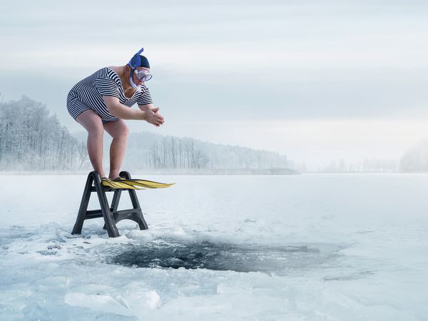 Ein Mann springt zur Kälteanwendung ins Eis.